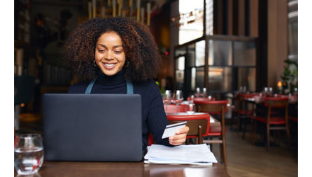 Woman working on a laptop computer at a restaurant Woman working on a laptop computer at a restaurant